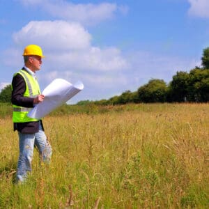 Construction worker surveying a field.