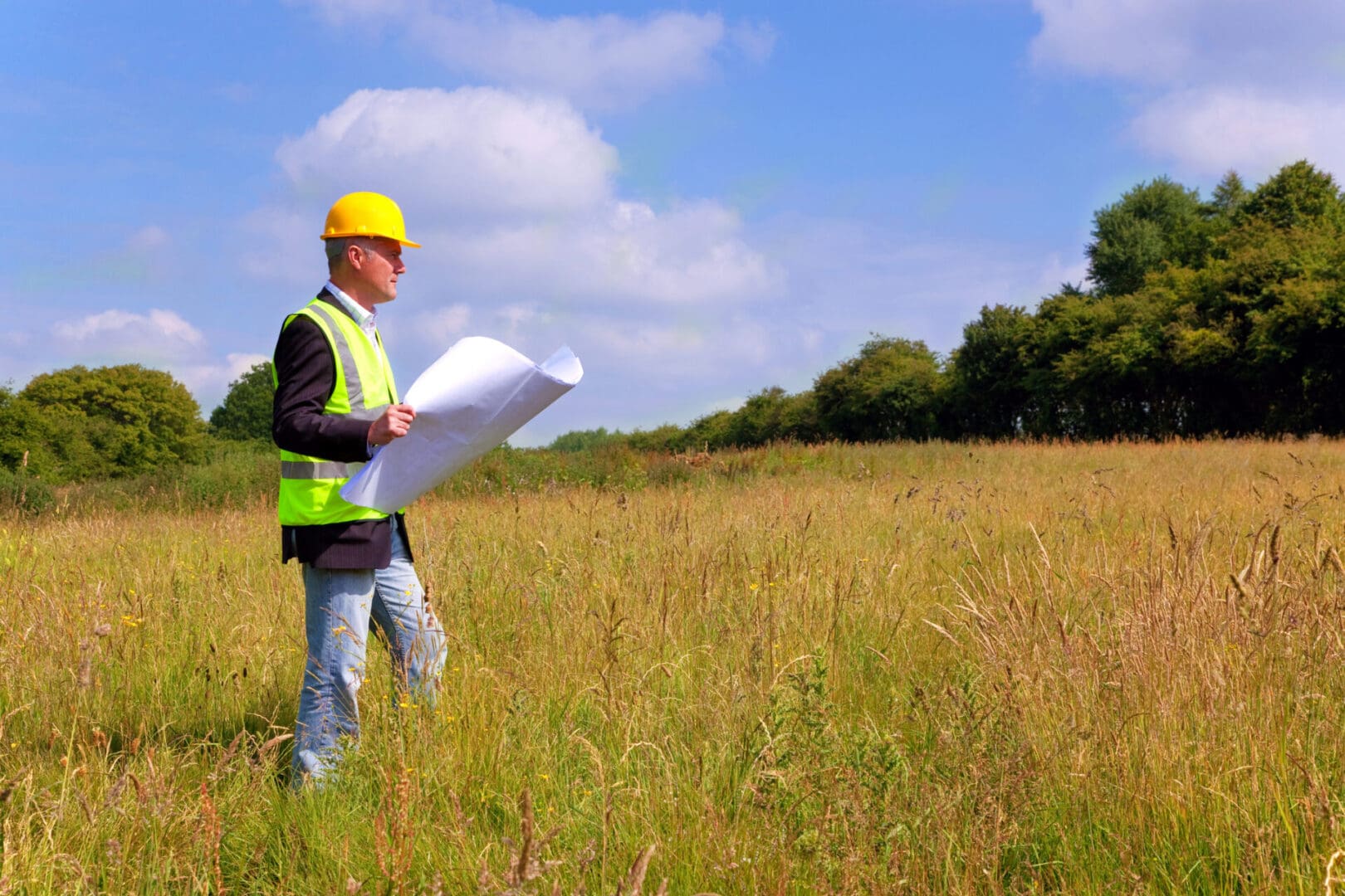 Construction worker surveying a field.