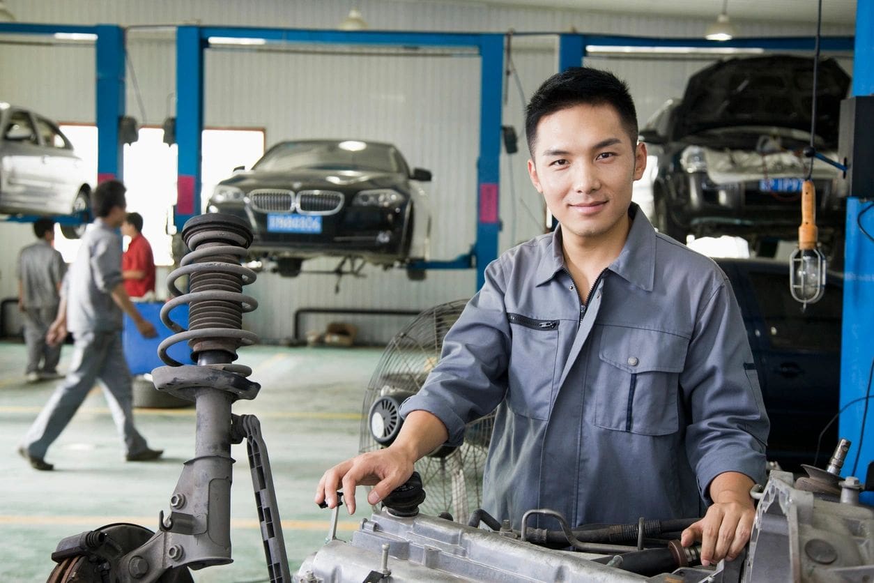 A man in blue shirt standing next to a car.