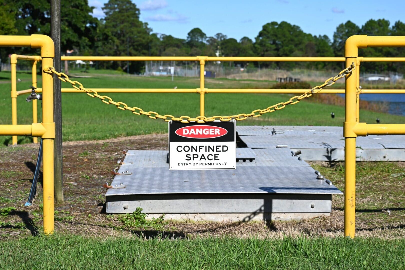 A sign that says confined space is posted on the ground.