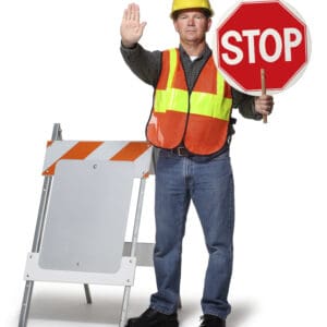 A highway or construction worker holding up a stop sign