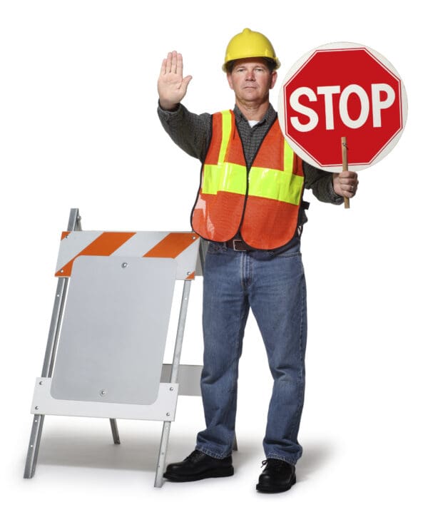 A highway or construction worker holding up a stop sign